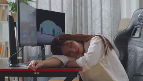 아시아 여성 자동차 디자이너가 스튜디오의 데스크 컴퓨터에서 ev 자동차의 3d 모델을 작업하는 동안 잠을 자는 측면 뷰