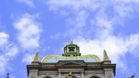 magnificent building in prague with angels statues on the sides holding declaration above and many other saint sculptures representing christianity golden parts of building at the top of the tower