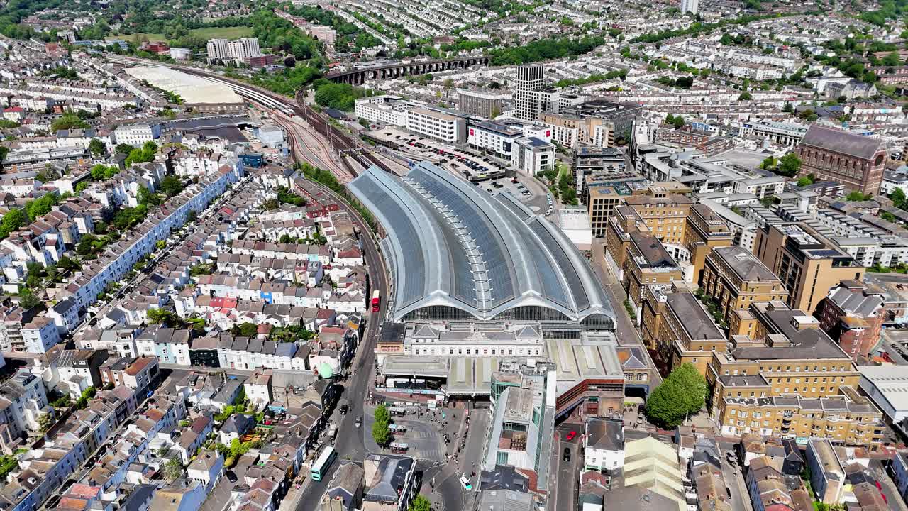 High-angle drone pan footage of Brighton train station and busy streets. One of the UK’s busiest coastal hubs.
