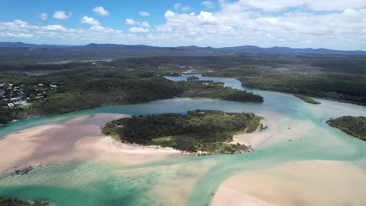 Red rock beach where corindi river meets ocean and lush bushland, aerial view