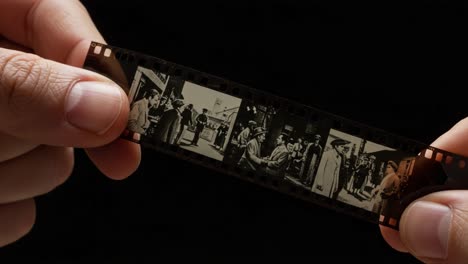 a close-up view of an historic film strip captured by hands, showcasing artistry and moments in time with stunning visual detail