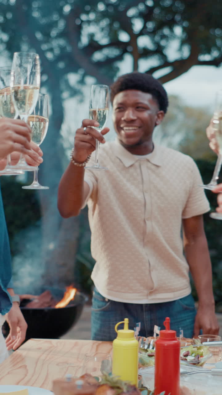 Venner, der skåler med champagne til en udendørs grillfest