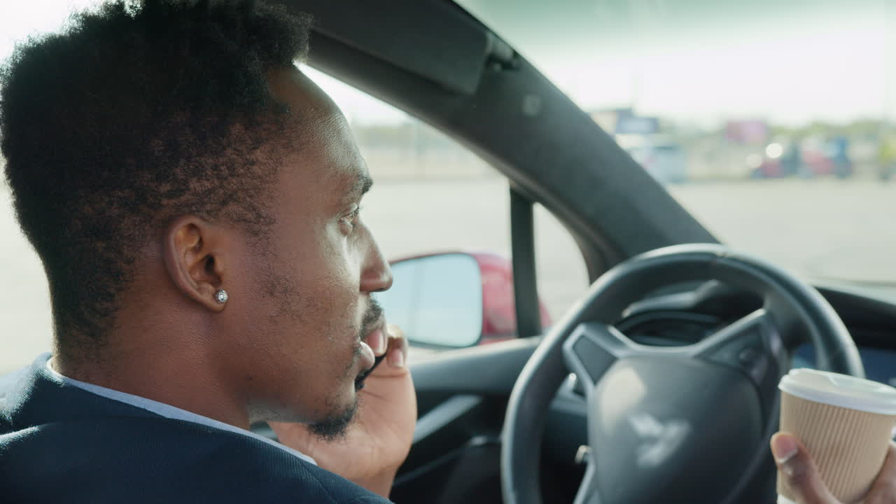 전기 자동차 에서 전화 로 운전 하고 대화 하는 사람