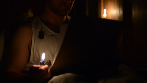 Soldier reading a letter at night with the help of a lighter