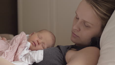 mother and newborn daughter sleeping together in daytime