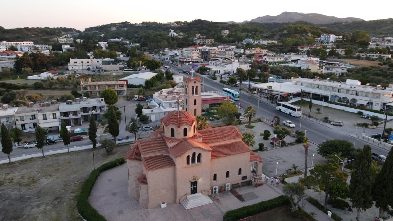 hermosa iglesia ortodoxa naranja en faliraki, rodas, órbita aérea durante la puesta de sol