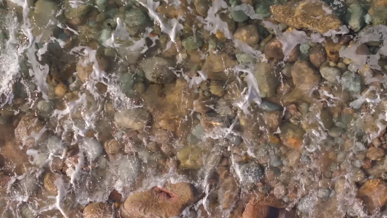 olas que chocan contra guijarros y rocas en la playa brana de lazo en camariñas, una coruña, españa