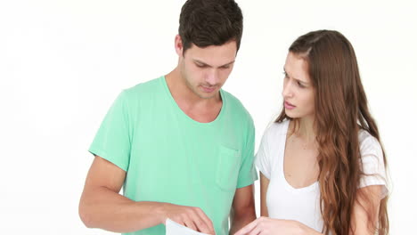 una pareja de jóvenes preocupados con facturas y calculadora.