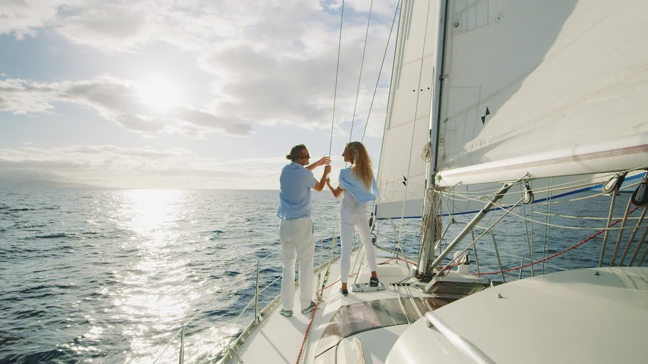 una pareja navegando hacia la puesta de sol.