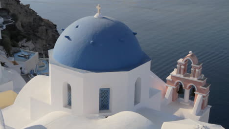 die berühmte blaue kirchenkuppel mit der rosafarbenen kirchenglocke in oia, santorini