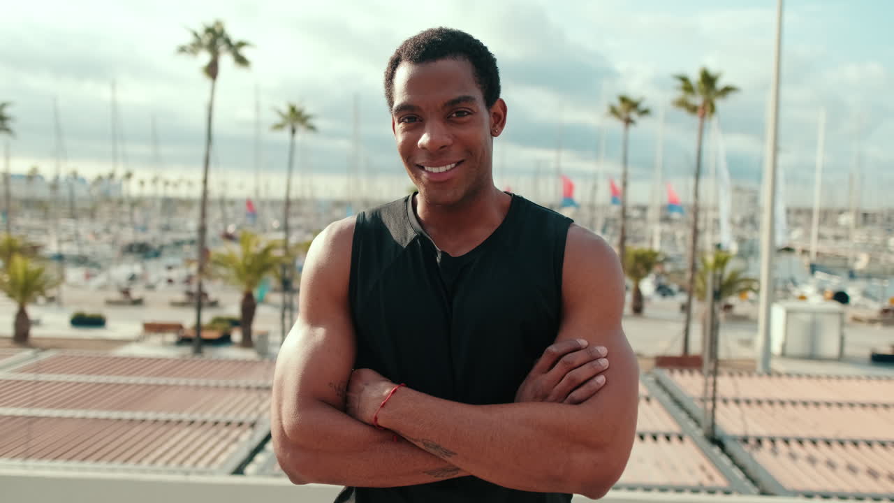 Hombre negro en forma sonriendo en el puerto deportivo