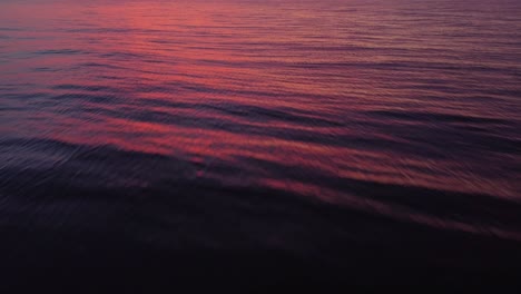Wasseroberfläche,-Die-Den-Farbenprächtigen-Sonnenuntergang-Widerspiegelt,-Neigung-Zum-Himmel