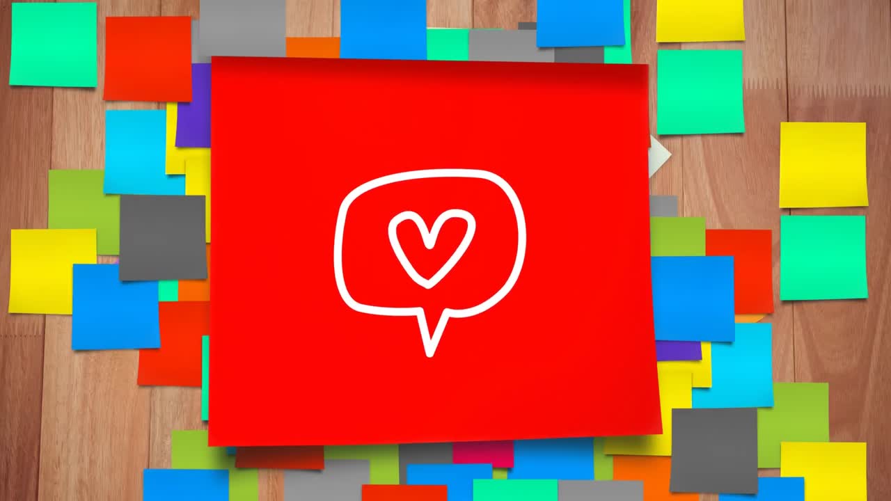 Animazione di una nuvoletta di dialogo bianca e di un'icona a cuore che sfarfallano su un foglio di carta rosso con post-it.