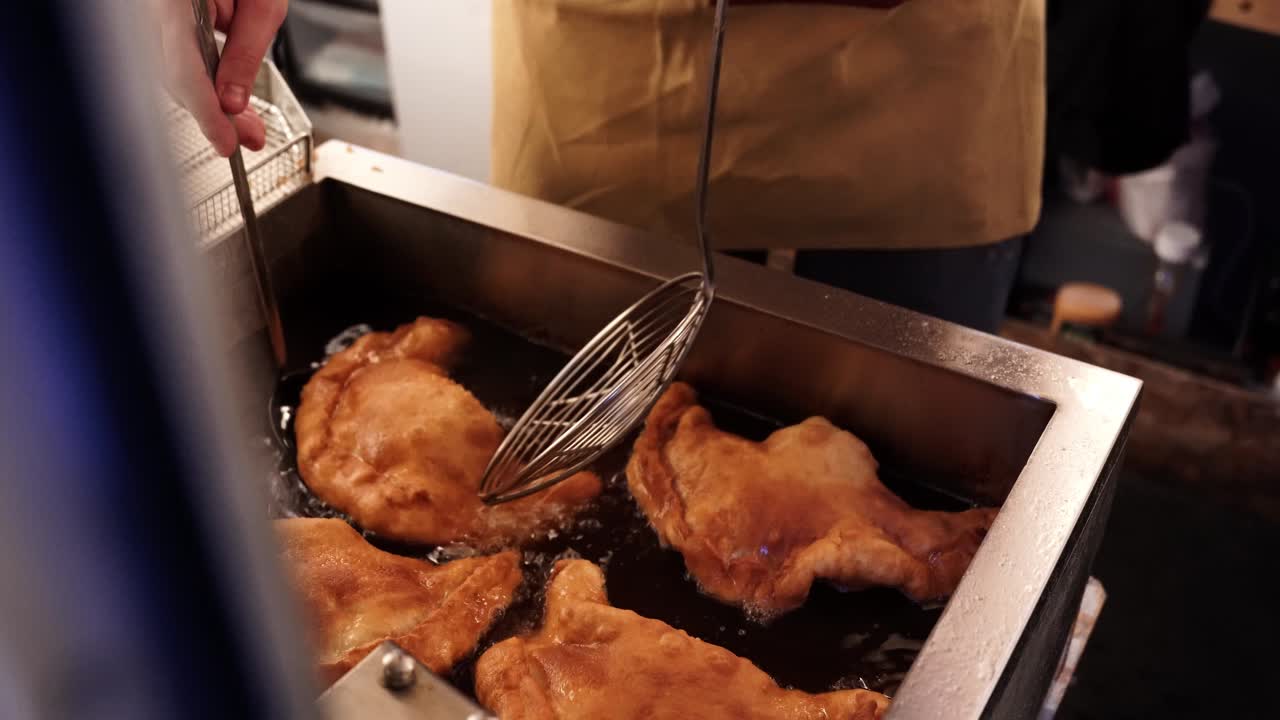 Food truck chef deep frying pizza in oil at local festival fair