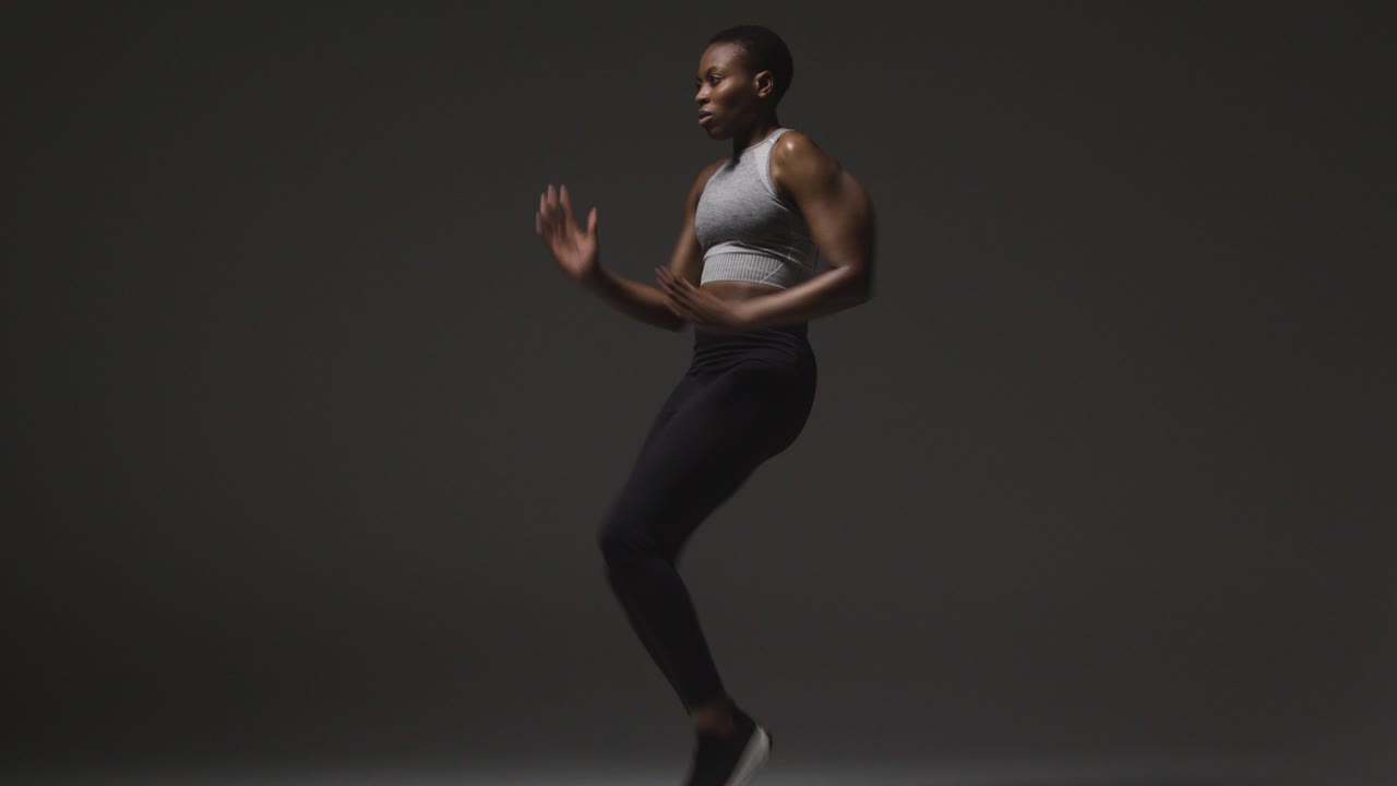 Studio Shot Of Woman Wearing Gym Fitness Clothing Exercising Running On The Spot 3