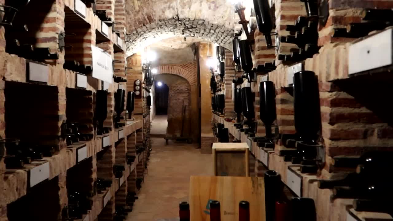 Panning right shot of aged wine bottles in a cellar, Aranda de Duero, Burgos