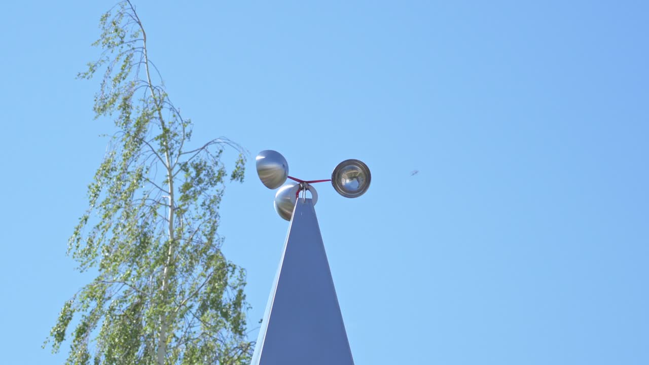 Metal cup-shaped weather vane rotates in the wind