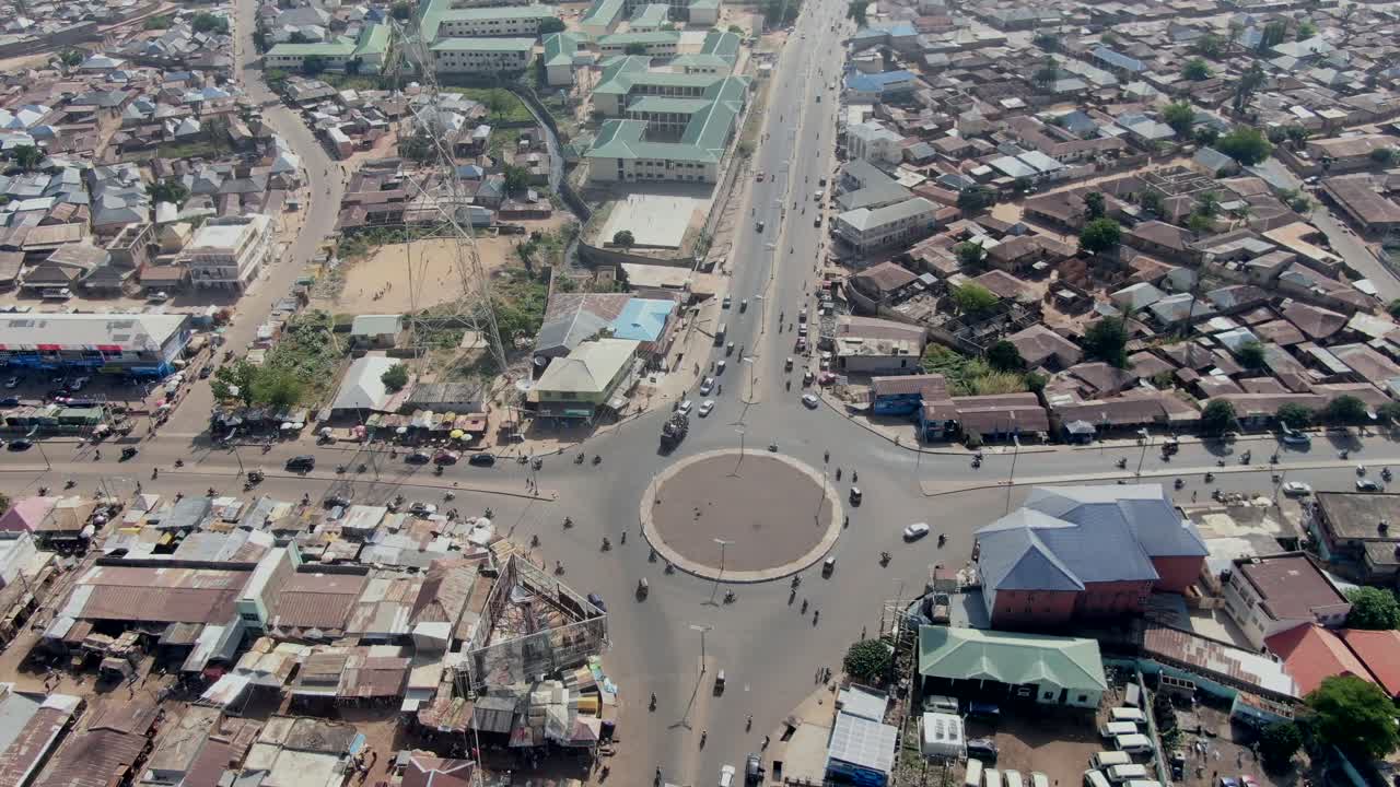 Rotatória com tráfego de carros e motocicletas em Gombe, Nigéria - órbita aérea
