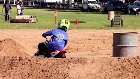 motorcyclist in blue maneuvers around barrels