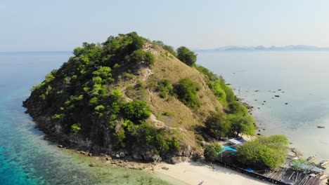 Hermosa-Toma-Aérea-De-Pulau-Kelor-Komodo,-Drone-Volando-Hacia-Atrás-Para-Revelar-Toda-La-Isla,-Mostrando-Su-Impresionante-Paisaje