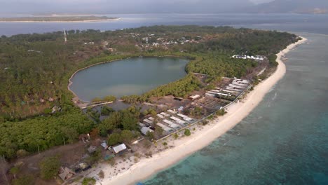 Vista-Aérea-épica-De-Gili-Meno-Durante-La-Luz-Del-Sol-Con-Playa-Dorada,-área-Del-Hotel-Y-Lago-Natural-En-Segundo-Plano