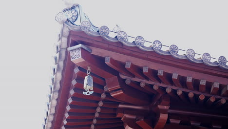 the iron bell hanging top roof in a chinese temple, ringing by wind