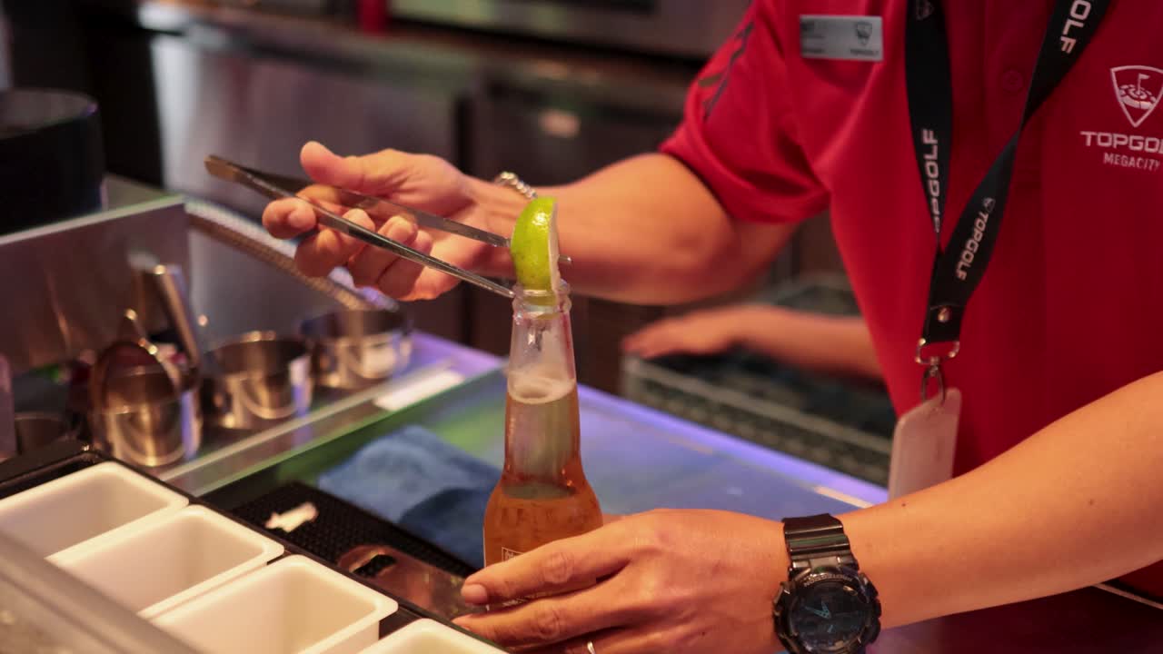 골프에서 바텐더가 맥주에 라임을 첨가합니다.