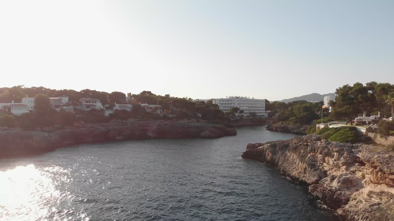 AEREA: Volo sopra una baia e la costa di Cala d'Or a Maiorca al tramonto.