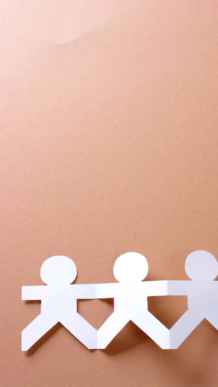 사본 공간과 함께 베이지색 배경에  종이로 만든 손을 잡고 있는 사람들의 클로즈업