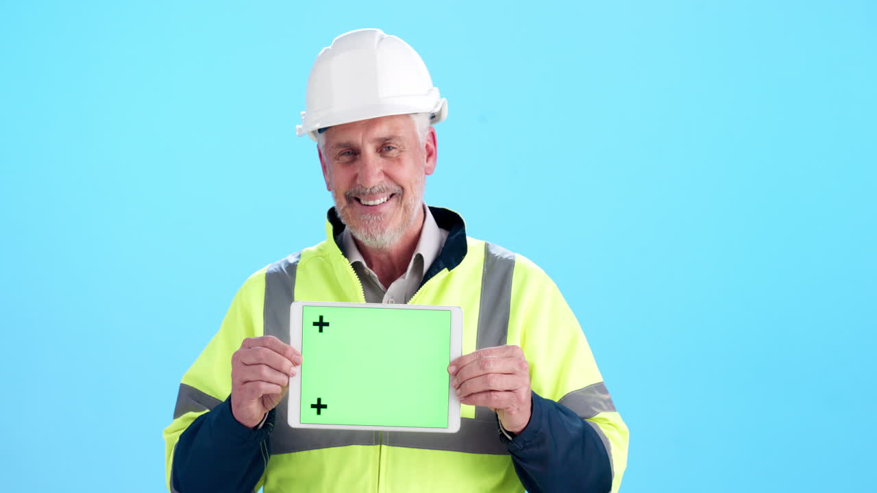 Construction worker holding a tablet with green screen
