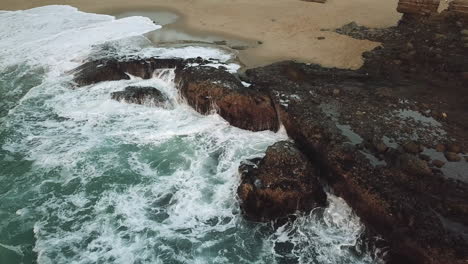 waves splash against rock formations in laguna beach california during winter