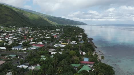 a town with tropical nature at plage vaiava beach in puna'auia, french polynesia. aerial drone shot