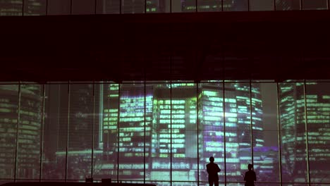 silhouettes in an office building against of skyscrapers