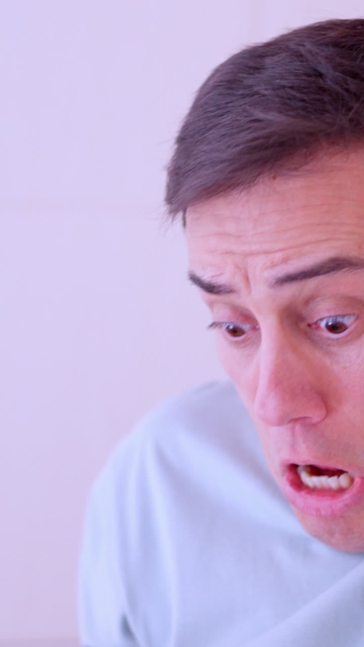 Man blowing nose and looking terrified at handkerchief