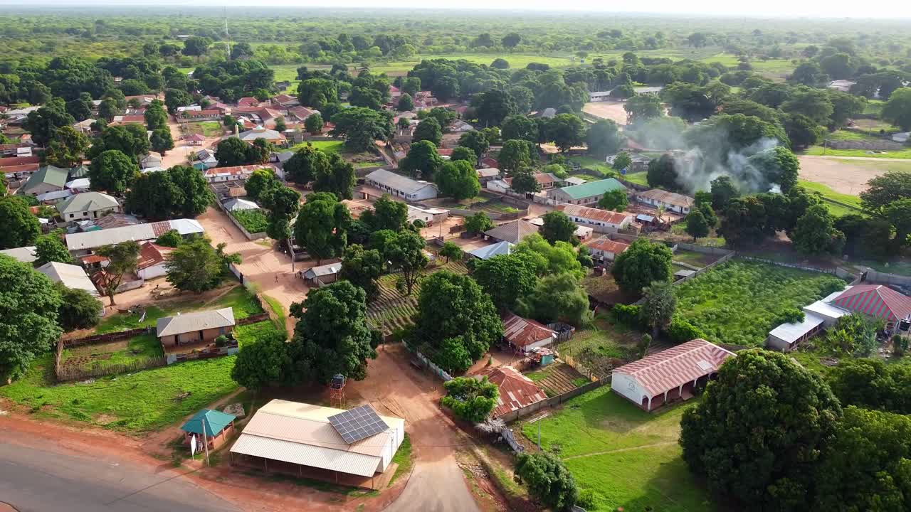 Aerial reverse rotating shot of rooftops with solar panels in Nuimi Lameng village in The Gambia