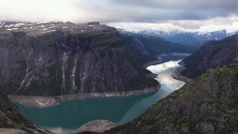 proud hiker stands triumphantly trolltunga rock ledge, norway