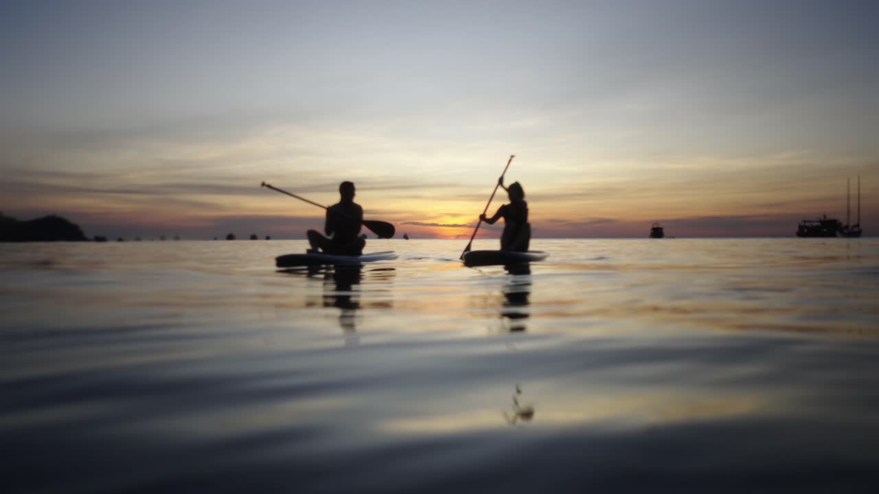 People Paddleboarding at Sunset