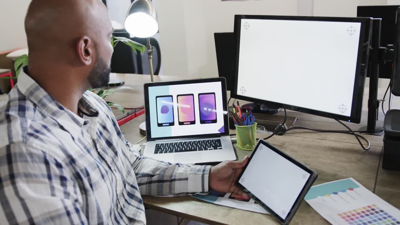 diseñador masculino biracial usando computadoras con espacio de copia en una oficina casual, cámara lenta