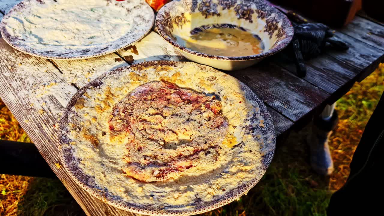 Rustic table holding pans with dough in a cozy outdoor setting