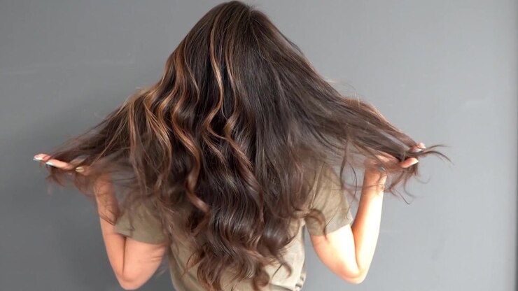 Cabello femenino blanco, ondulado y voluminoso, moviéndose lentamente después de ser peinado.