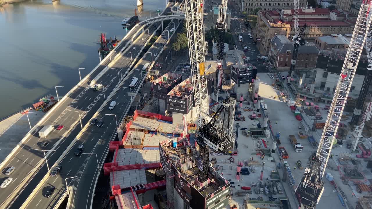 потрясающий вид на город ранним утром с видом на застройку queens wharf в брисбене с автострадами в час пик, рекой и мостами