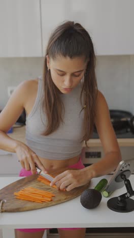 woman chopping carrots in a kitchen for a healthy meal