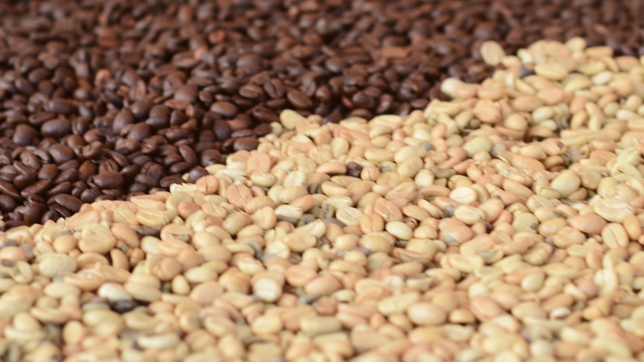 Cinematic macro shot revealing a pile of fresh dark roast coffee beans ready for grinding in a professional roastery.