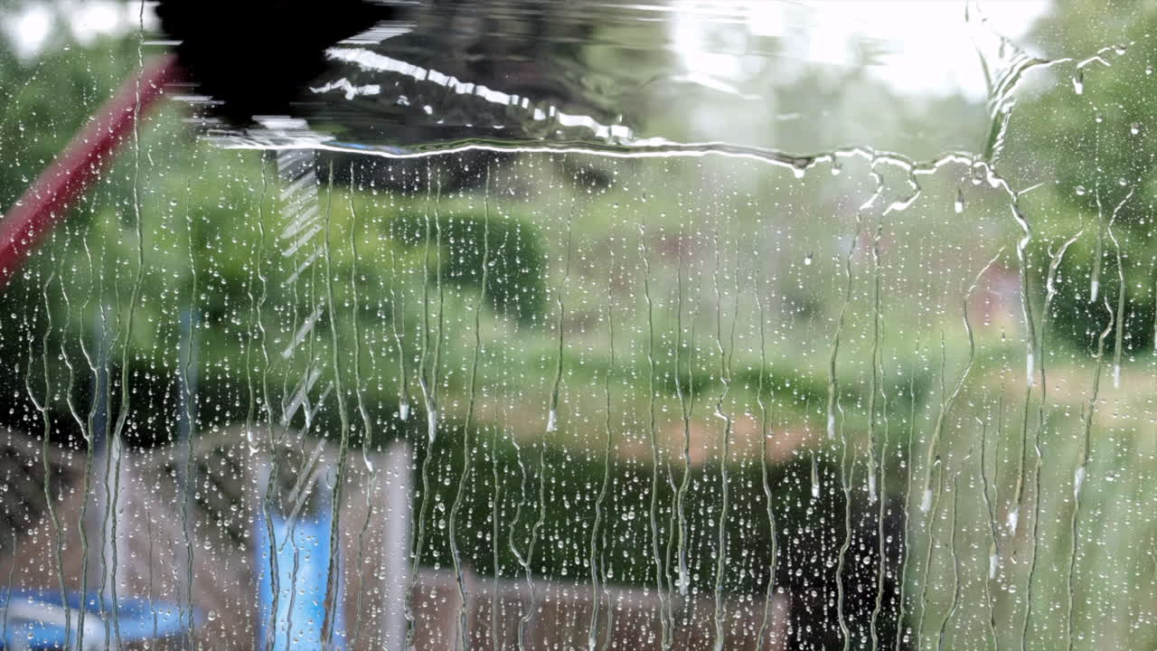 una ventana de la casa que se limpia y lava con un sistema de cepillo alimentado con agua en un poste largo