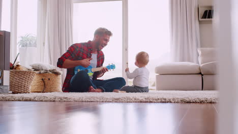 Dad-and-toddler-son-playing-with-instruments,-full-length