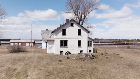 Old-abandoned-home-with-broken-windows-and-graffiti-sits-empty-in-ruins-on-vacant-property-lot-near-water