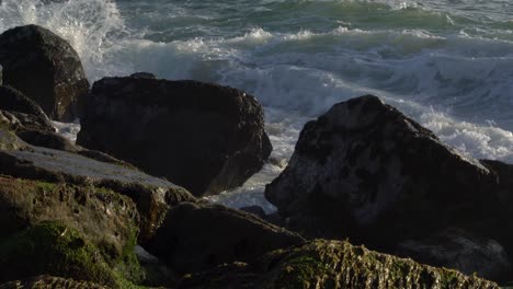 Close-Up,-gentle-waves-crashing-on-rocks,-Furadouro,-Portugal