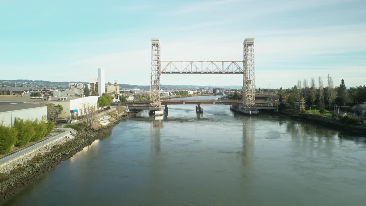 Overhead aerial perspective displays the Miller Sweeney Bridge as it spans the water, connecting Alameda to Oakland.