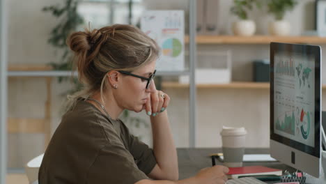 Geschäftsfrau-Analysiert-Diagramme-Am-Computer-Im-Büro