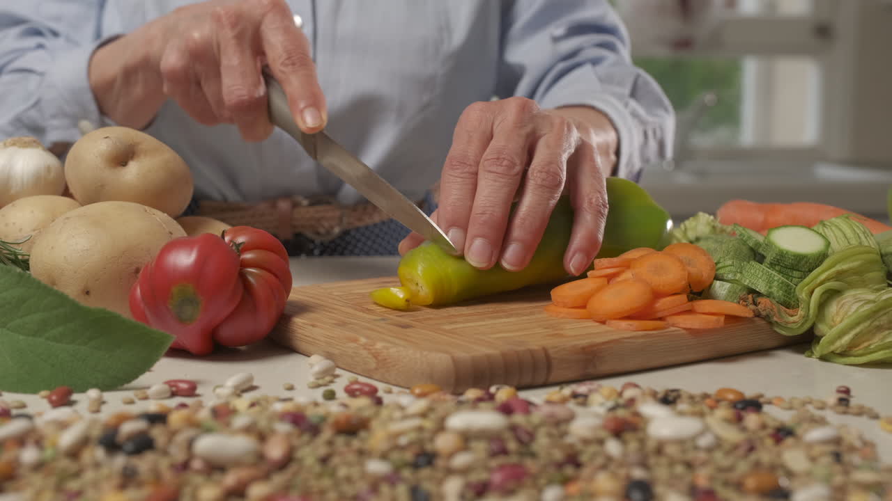 mujer preparando comida en casa, cortando verduras para receta vegetariana vegana, dieta mediterránea nutrición saludable